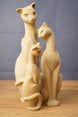Grouped Tarkov inspired cat figurine replicas with smooth beige finish, elegant seated poses, curved tails, and sculpted facial details.