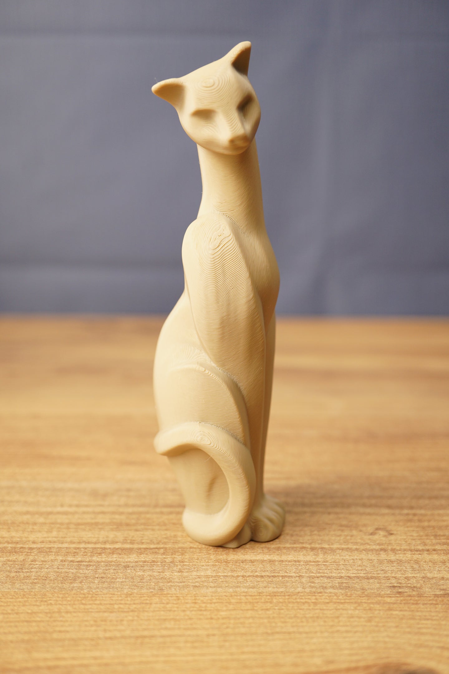 Single beige Tarkov inspired cat figurine replica standing on a wooden desk, featuring a tall elegant body, pointed ears, and curved tail.