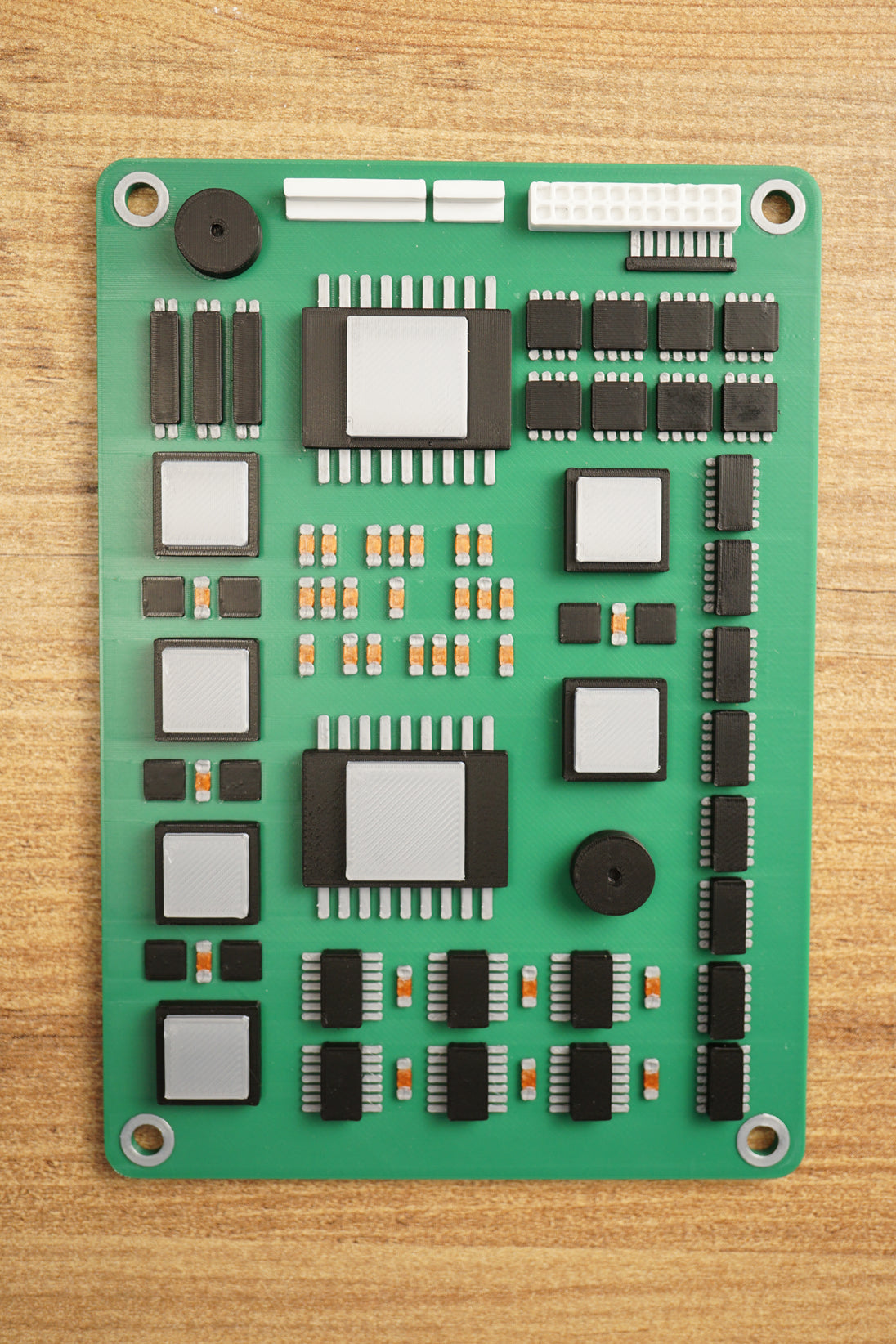 Close-up angled view of a Tarkov inspired military circuit board replica with raised black chips, silver components, orange accents, and white connector port.