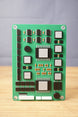 Front view of a military circuit board replica with detailed chips, silver raised parts, orange component accents, and rounded corner mounting holes.