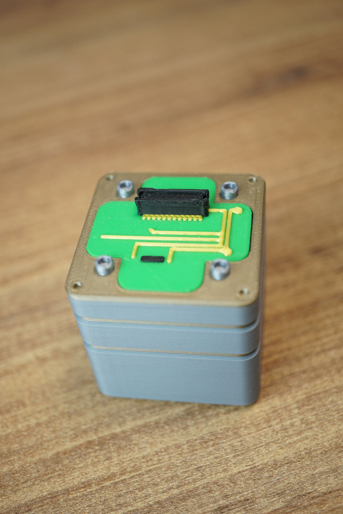 Top view of an Iridium thermal vision module replica prop with green circuit detail, grey casing, corner screw accents, and black connector.