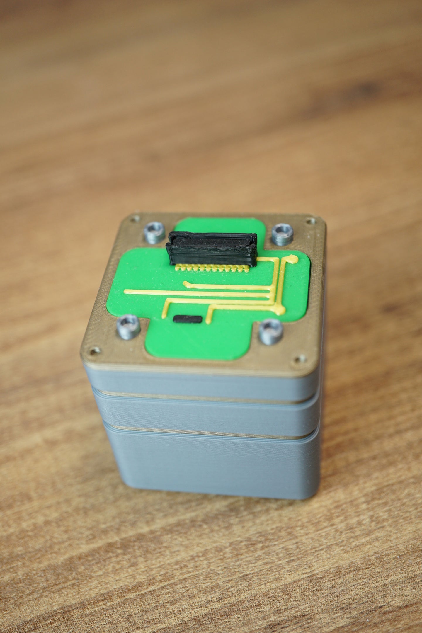 Top view of an Iridium thermal vision module replica prop with green circuit detail, grey casing, corner screw accents, and black connector.