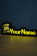 Lit ultimate ironman nameplate with a silver helmet icon, yellow RuneScape-style lettering, and a soft glow reflected on the tabletop.