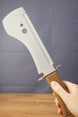 Hand holding a 3D-printed UVSR Taiga-1 survival machete replica with a gray blade and brown textured handle.