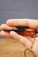 VSS Vintorez style gamer keychain held in hand, showing compact rifle profile, scope detail and attached keyring chain
