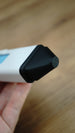 Macro photograph of the WARDOGS Adrenaline Pen gaming prop showing the black tapered tip and textured surface against the white outer body.