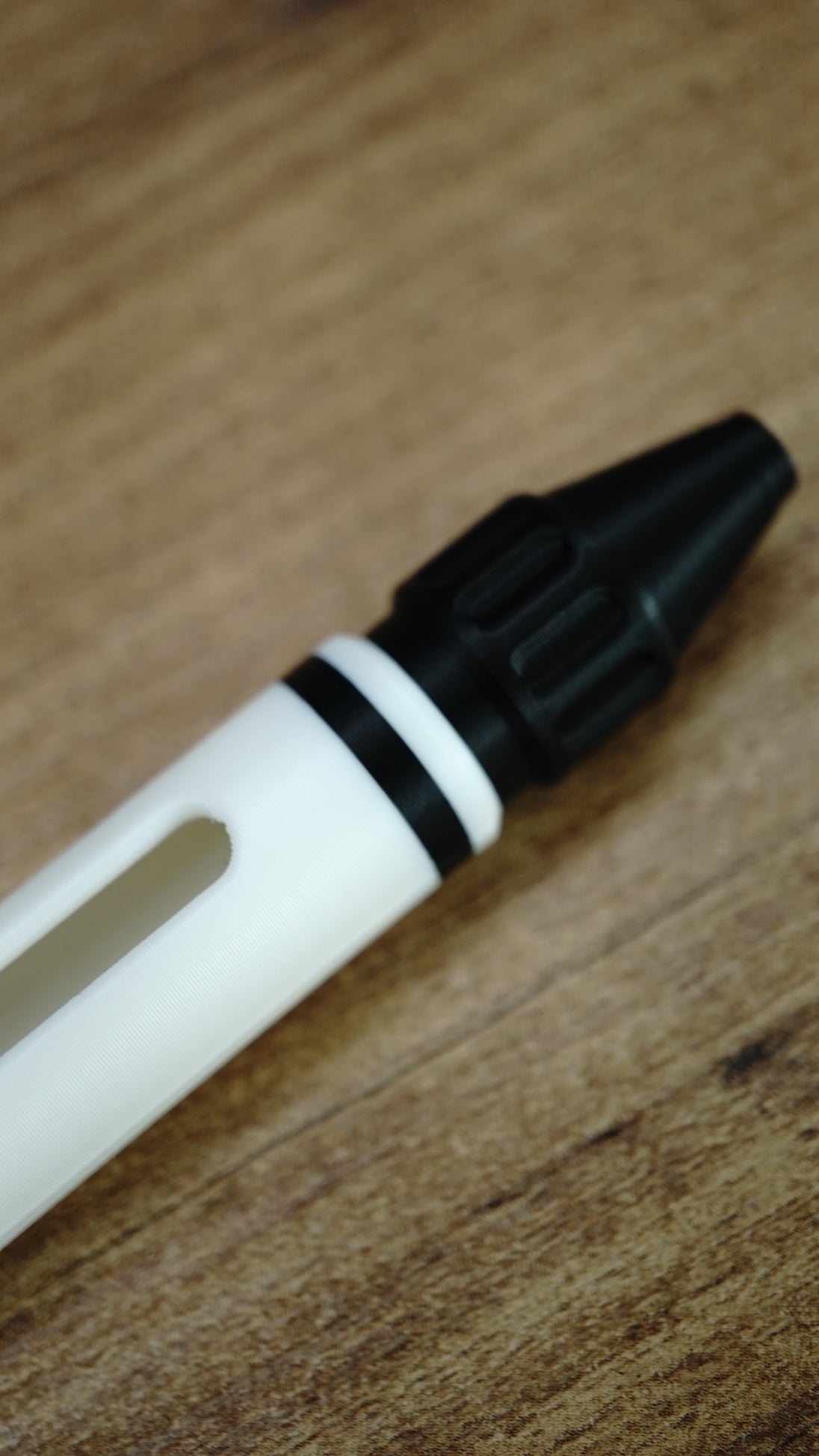 Close-up of the textured black front section and white body of the WARDOGS Adrenaline Pen replica, showing the detailed gaming prop design.