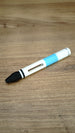 WARDOGS Adrenaline Stim Pen replica with white and blue body, black front section and elongated side opening, displayed on a wooden desk.