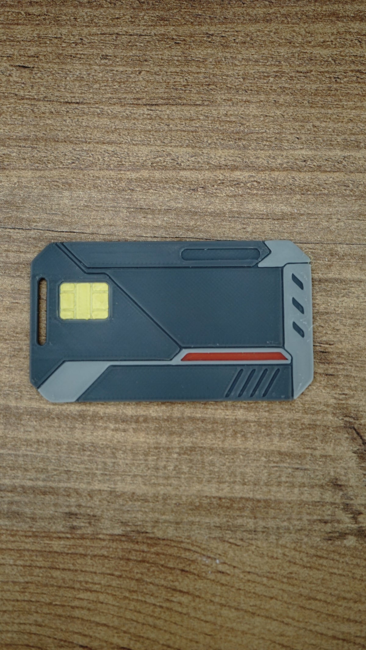 Front view of the WARDOGS Alpha Card 1 collectible keycard with yellow chip detail, red accent stripe and grey tactical-style panels.