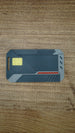 Front view of the WARDOGS Alpha Card 1 collectible keycard with yellow chip detail, red accent stripe and grey tactical-style panels.