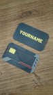 WARDOGS Alpha Card 1 keycard replica shown beside a personalised card back with yellow name lettering, featuring detailed tactical styling and grey accents.