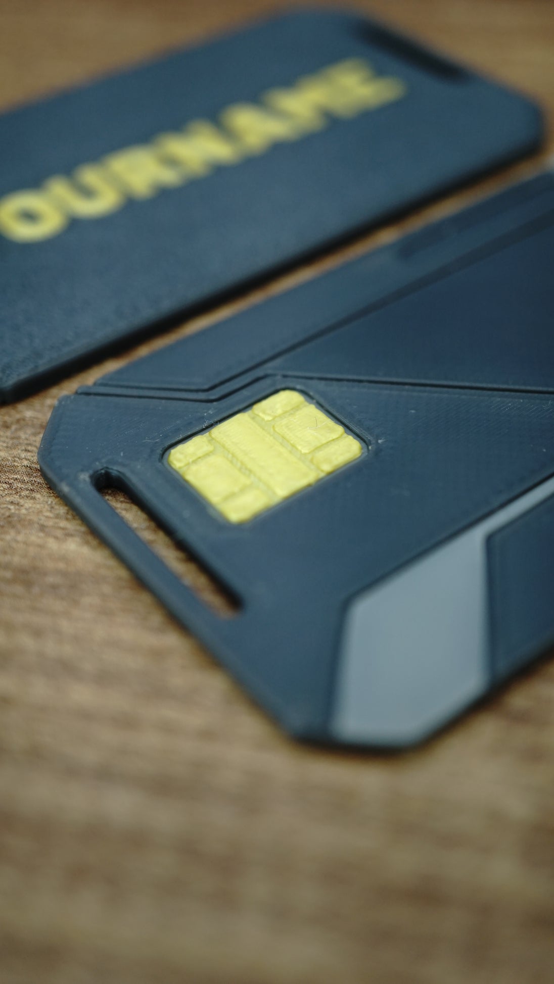 Detailed close-up of the WARDOGS Alpha Card 1 replica showing its yellow chip-style feature, dark grey body and geometric panel lines.