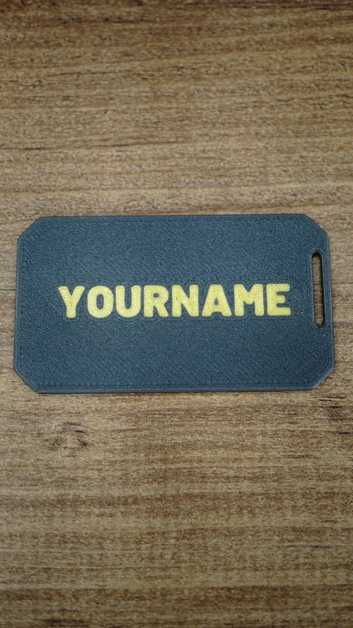 Reverse side of a personalised WARDOGS Alpha Card 1 gaming keycard with a custom name in bold yellow lettering on a textured dark grey surface.