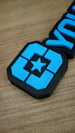 Angled close-up of the Lonestar Blue nameplate's bright blue star and geometric faction emblem, with part of the raised lettering visible behind it.
