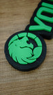 Close-up of the Manticore Green lion faction emblem with bright green raised detailing, a circular design and contrasting black nameplate backing.