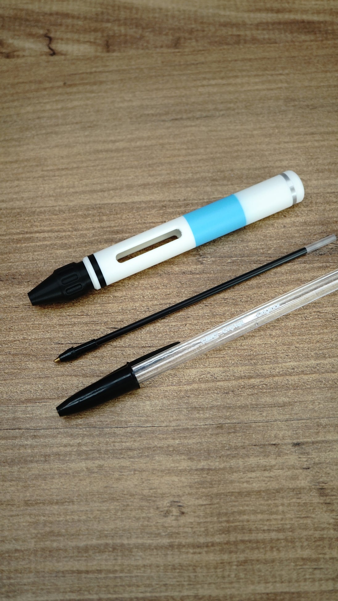 WARDOGS Adrenaline Stim Pen casing displayed with a black ballpoint refill and a transparent BIC-style pen to illustrate the writing pen setup.