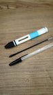 WARDOGS Adrenaline Stim Pen casing displayed with a black ballpoint refill and a transparent BIC-style pen to illustrate the writing pen setup.