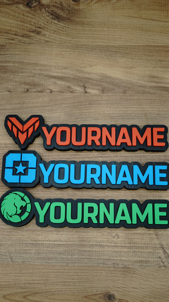 Three WARDOGS-inspired gaming nameplates arranged horizontally, showing Valkyra Red, Lonestar Blue and Manticore Green faction designs with YOURNAME text.