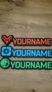 Three WARDOGS-inspired gaming nameplates arranged horizontally, showing Valkyra Red, Lonestar Blue and Manticore Green faction designs with YOURNAME text.