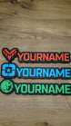 Three WARDOGS-inspired gaming nameplates arranged horizontally, showing Valkyra Red, Lonestar Blue and Manticore Green faction designs with YOURNAME text.